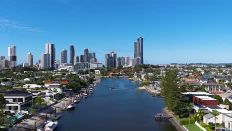 drone footage captures gold coast's skyline and waterways under clear blue skies, showcasing urban architecture and natural beauty