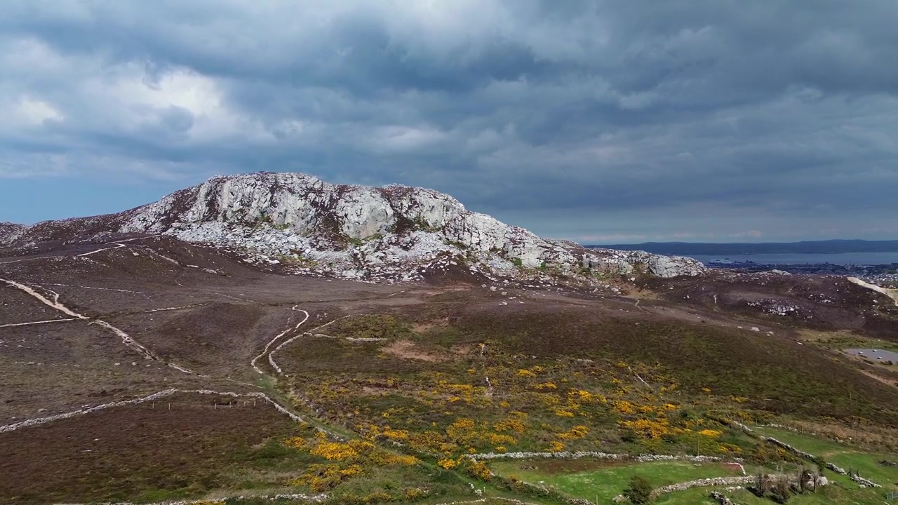 Walisisk hedelandskab ved foden af Holyhead-bjergets top, luftfoto der stiger op over et sommerhus