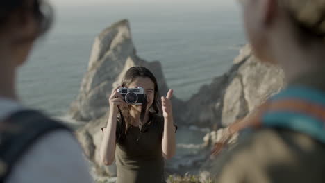 front view of a teenager girl taking photo of her family while hiking in mountains