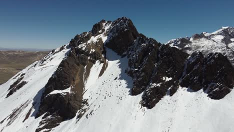 Aerial-orbits-Bolivian-Andes-snowy-mountain-summit-on-high-altiplano