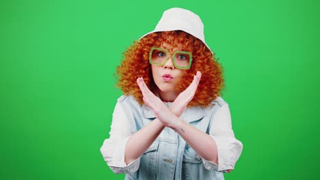 restriction concept. studio portrait of young redhead curly woman saying no and crossing hands, rejecting and denying