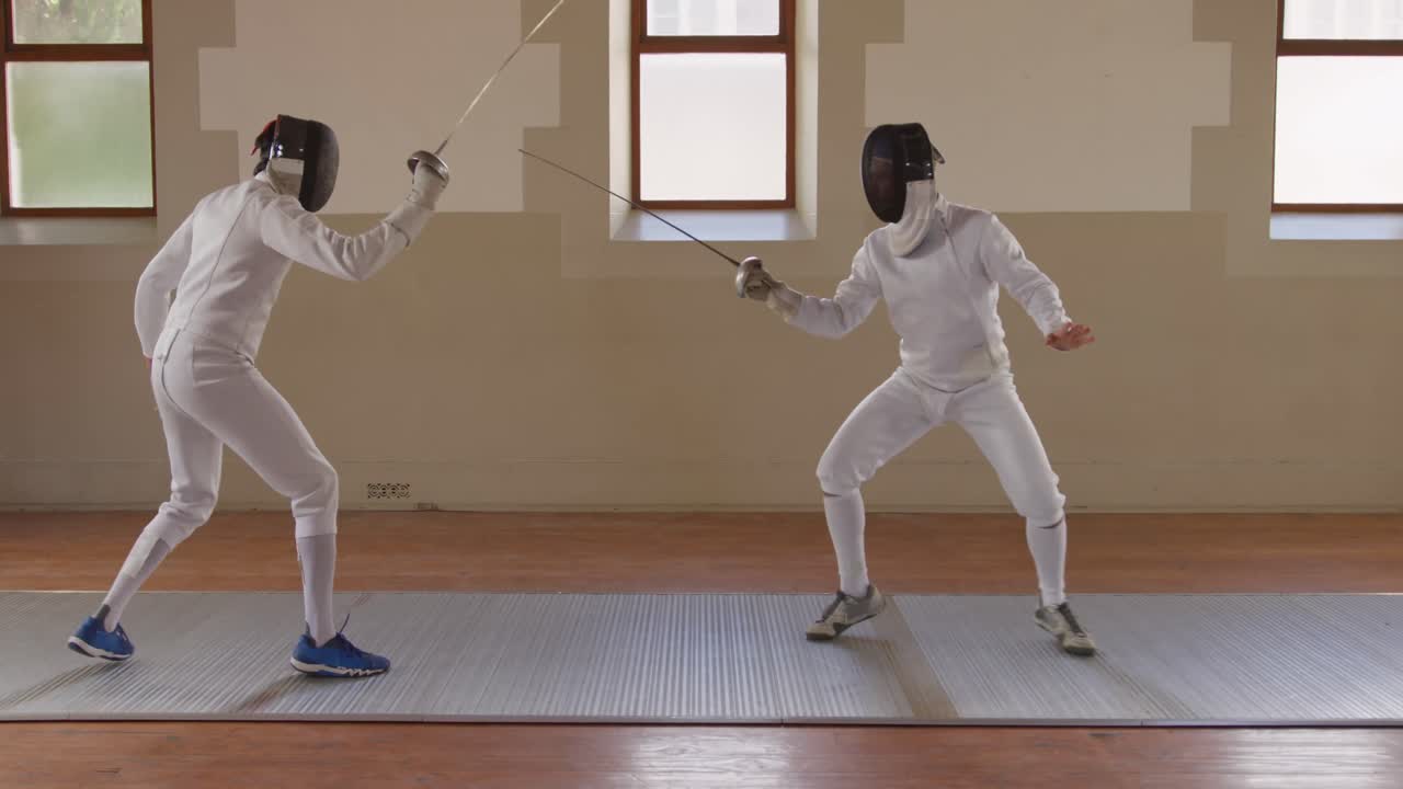 체육관 에서 펜싱 훈련 을 하고 있는 펜싱 선수 들