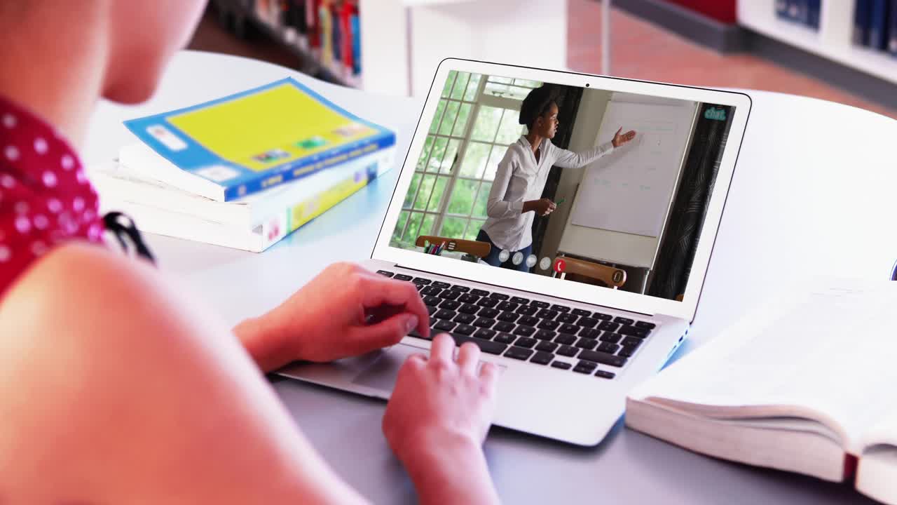 mujer de negocios caucásica sentada en un escritorio usando una computadora portátil haciendo una videollamada con una colega