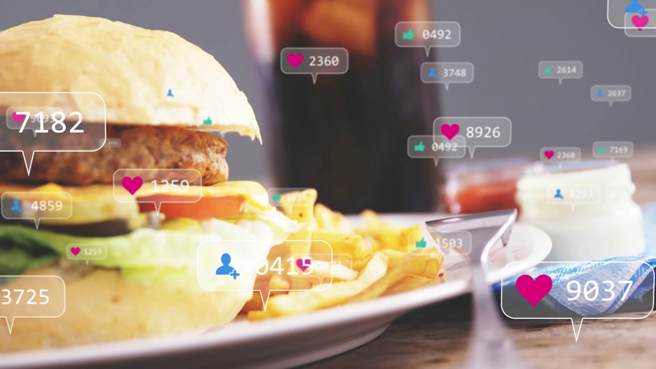 Cámara alejándose sobre una hamburguesa y patatas fritas con cola, reacciones animadas mostrando un creciente entusiasmo por la comida.