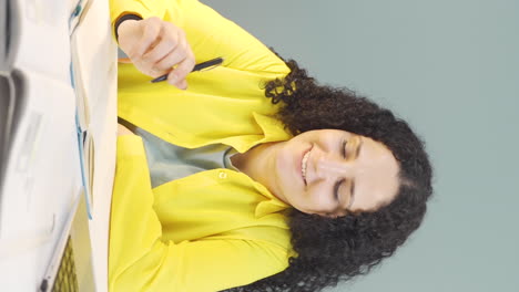 Vertical-video-of-Young-woman-looking-at-laptop-is-thoughtful.