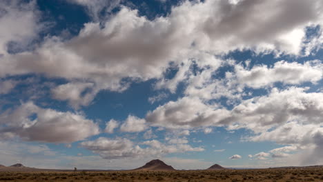 las nubes cumulus crean formas abstractas sobre los conos volcánicos en el desierto de mojave - lapso de tiempo estático