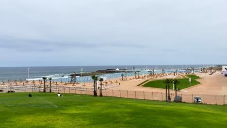 an aerial view of a beautiful tropical beach and sea with umbrella and chair around swimming pool in hotel resort for travel and vacation