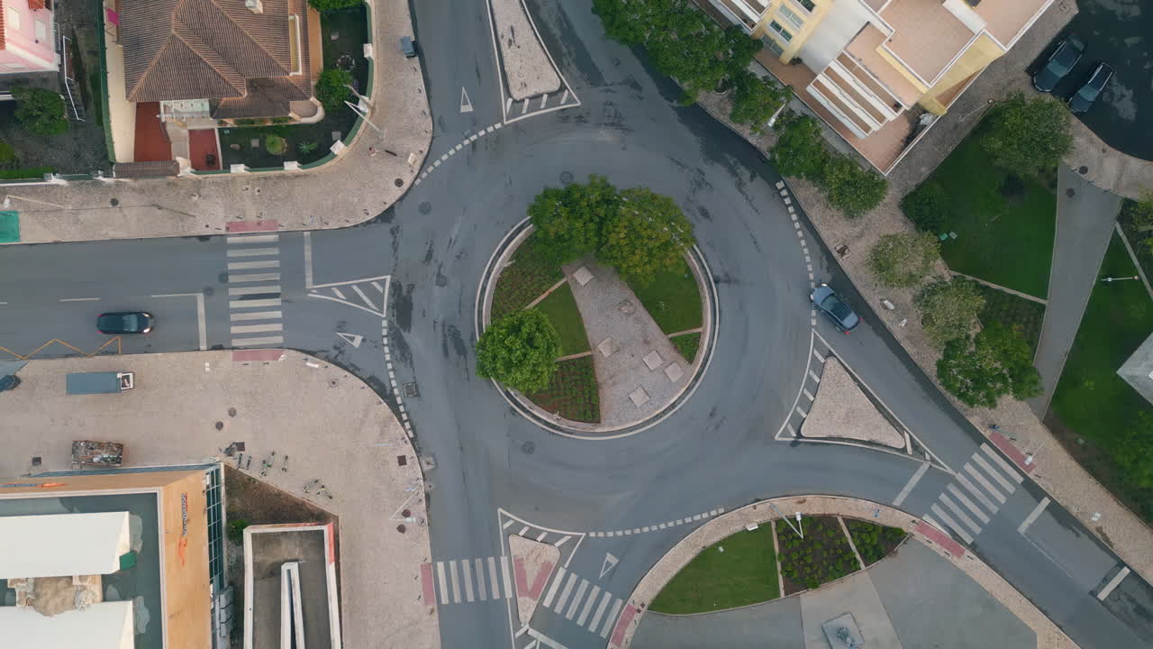 Urban circular traffic top view at cozy european town district. Green roundabout