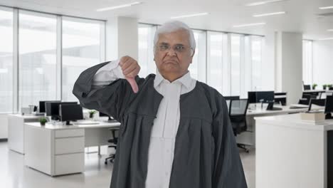 el abogado senior indio decepcionado mostrando los pulgares hacia abajo