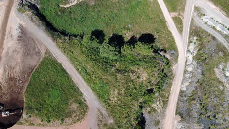 Bird's-eye-view-of-mining-company-field-with-bulldozer-and-several-kinds-of-different-terrains-and-levels