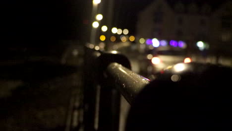 Focus-Pull-of-Car-driving-along-street-at-Night-in-Coastal-Village,-Pembrokeshire,-West-Wales