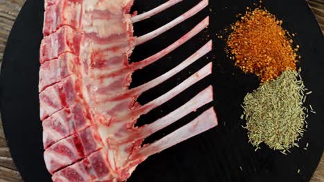 costillas de carne cruda e ingredientes en tablero de madera