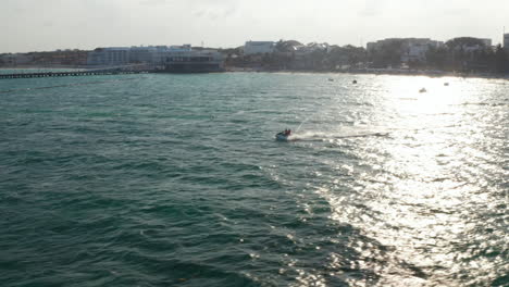 Riding-the-waves-with-jet-ski-while-cruising-on-the-Caribbean-Sea-at-Playe-del-Carmen,-Mexico