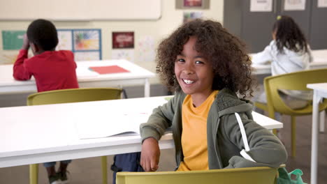 smiling student sitting in classroom, enjoying school day with open book, copy space