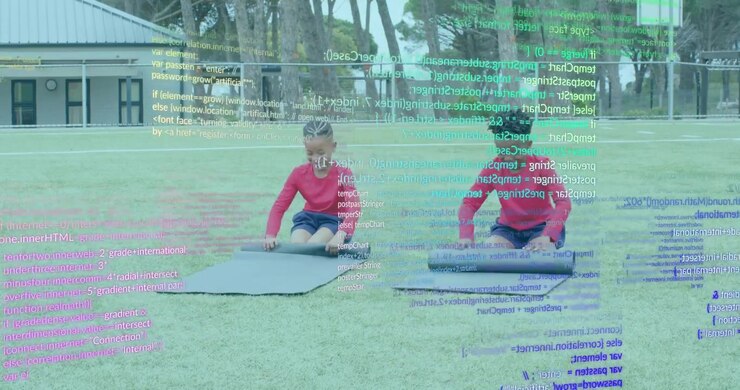Two boys kneeling on grassy field reaching and unrolling dark mats, smoothing creases for fitness