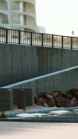 a concrete wall with a metal railing along the shore