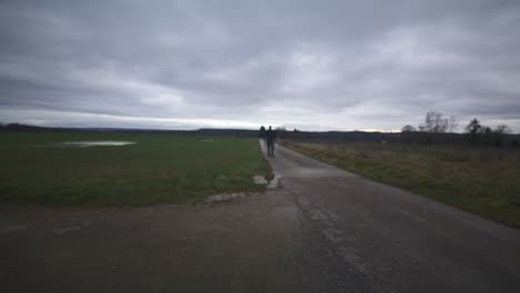 Modern-Black-Swordsman-Warrior-Awaiting-Battle-Opponent-in-Open-Field-Under-Grey-Sky,-Europe,-4K-|-Muscular,-Intimidating,-Shadow,-Figure,-Blurry,-Dark-Clothes,-Powerful,-Blurry,-Distant-Walk,-Puddle