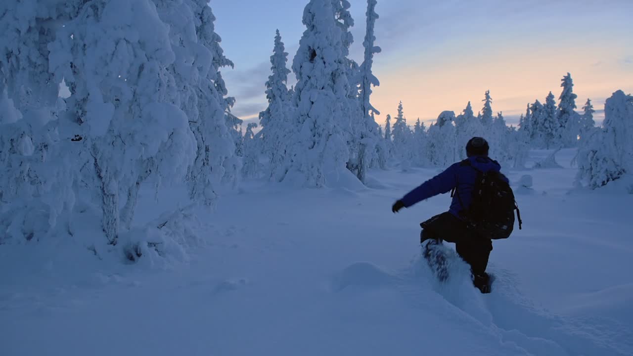 A Man With A Backpack Walking Along The Knee Deep Snow In The Region Of Lapland. -wide shot