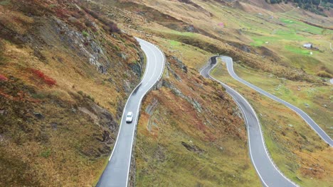 a car on furka pass road in switzerland in autumn