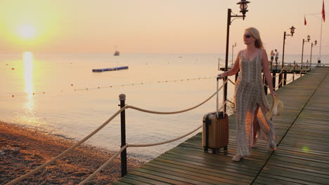 young happy tourist hurries to a settlement in the hotel after meeting the raft on the sea pier earl