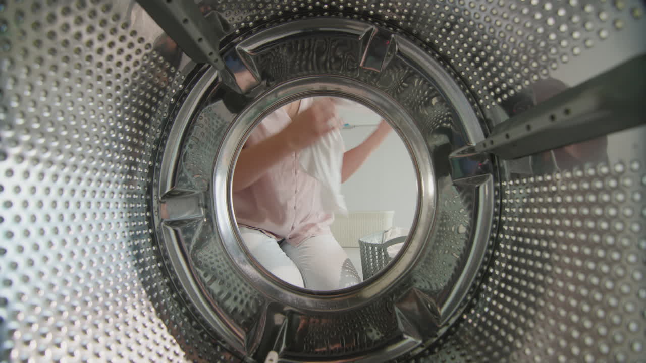 mujer pone ropa blanca dentro de la lavadora 1