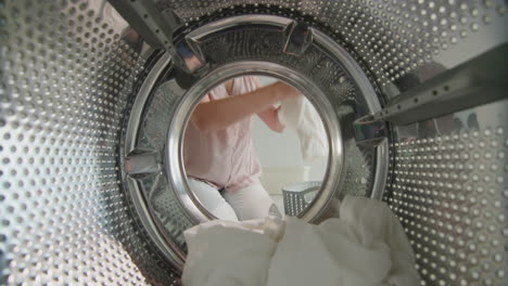 Woman-puts-white-linen-inside-washing-machine-1