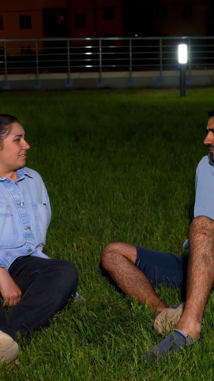 밤 에 풀 위 에 앉아 있는 부부