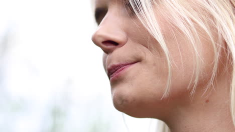 a side shot of a young woman eating ripe blackberries from the garden