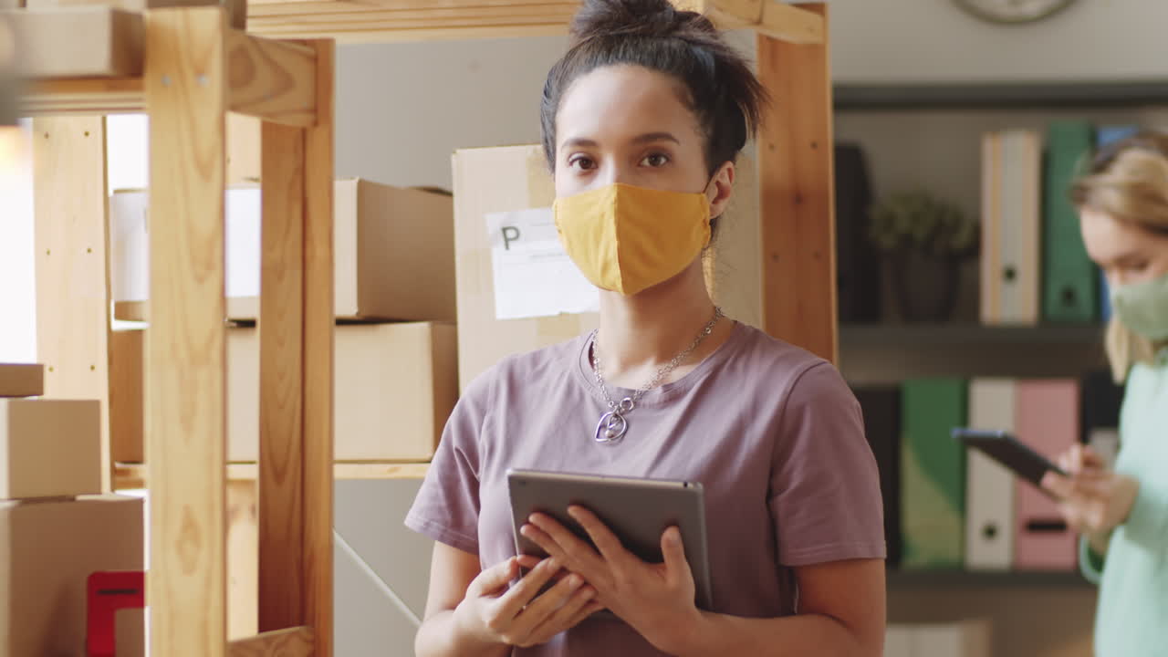 trabajadores de almacén con máscaras faciales y tabletas