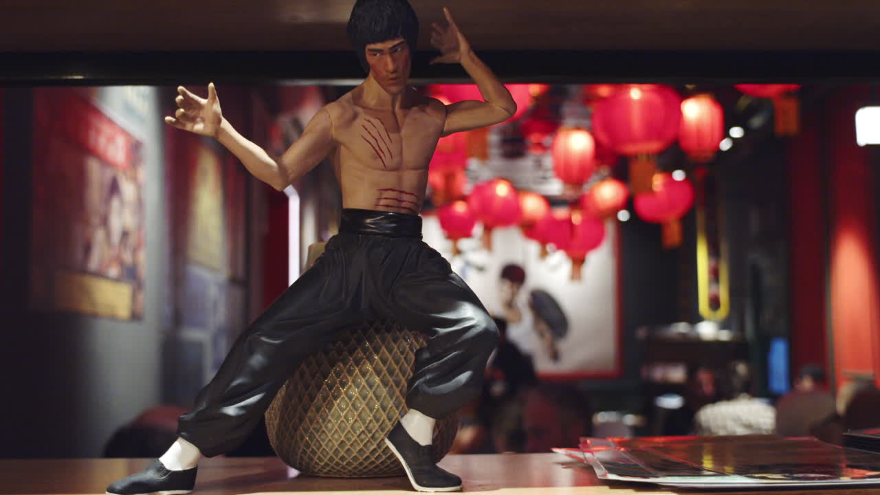 Close-Up of Bruce Lee Figurine in Iconic Pose at Kung Fu Themed Chinese Restaurant with Red Lanterns and Classic Modern Decor