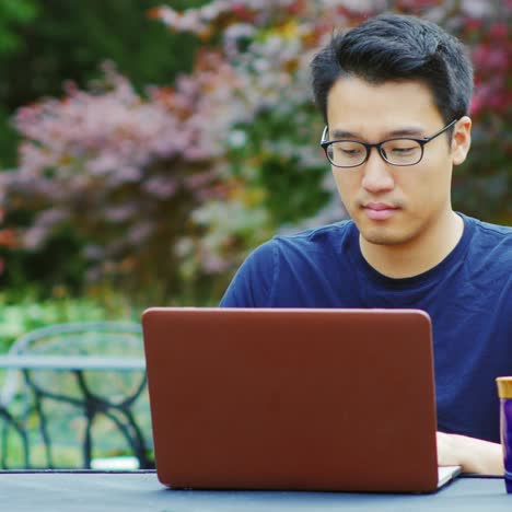 Un-Joven-Asiático-Trabaja-Con-Una-Computadora-Portátil