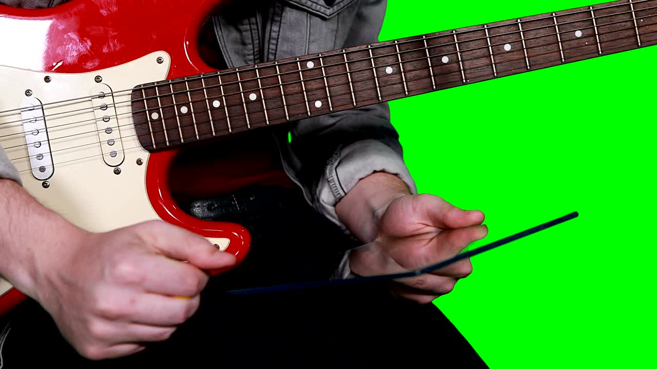 hombre sosteniendo una tableta digital mientras toca la guitarra