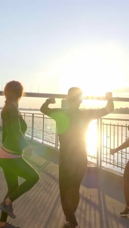 happy friends celebrating a workout by the river