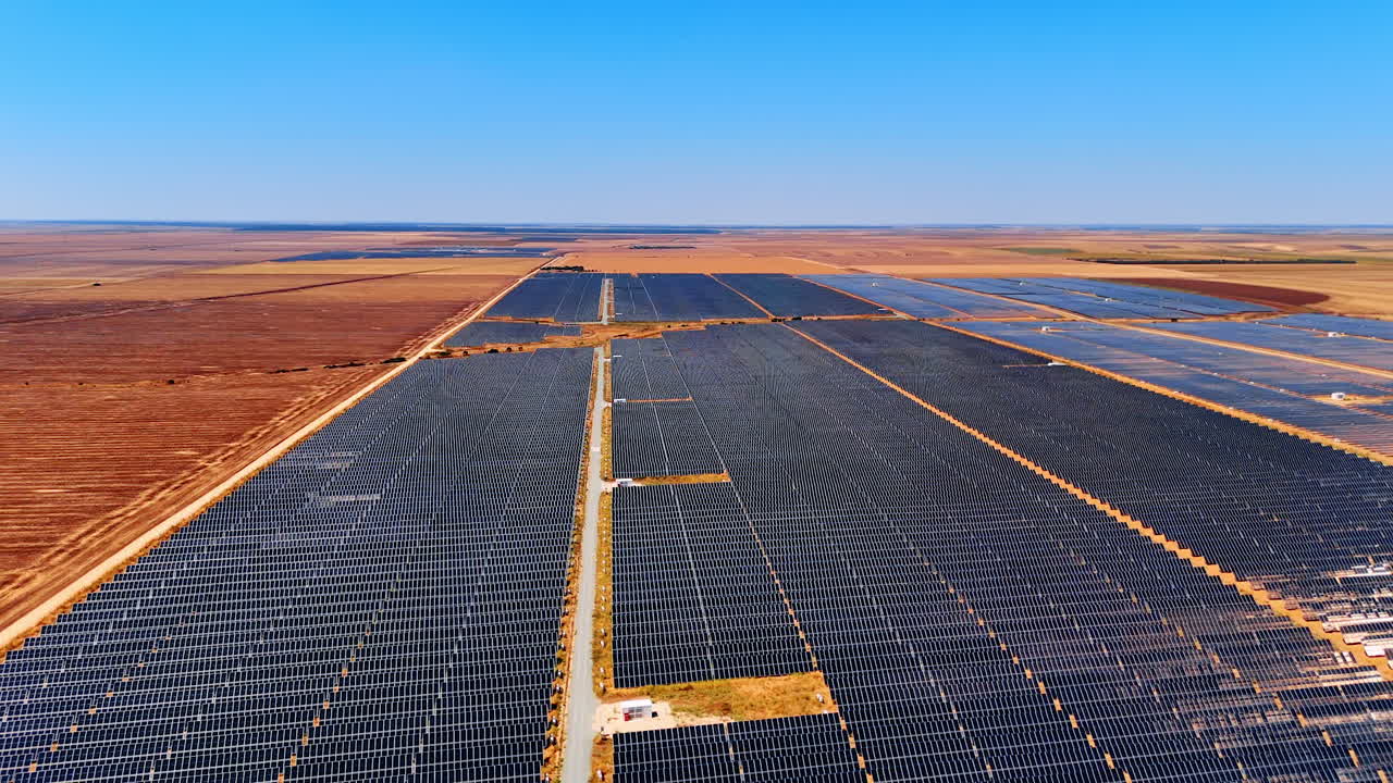 Vast fields covered with solar panels. Drone flight over the open space used for sustainable energy production