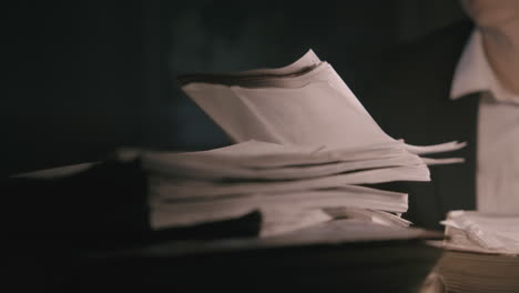 pale bald accountant looks through the tax papers in the weird room at night