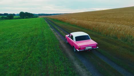 pink vintage car on a country road