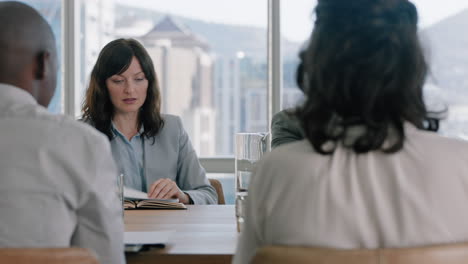 beautiful business woman in boardroom meeting looking at corporate documents discussing project with colleagues sitting at table working on planning success strategy in office 4k