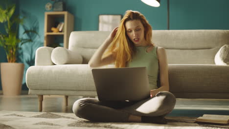 woman sitting on floor using laptop