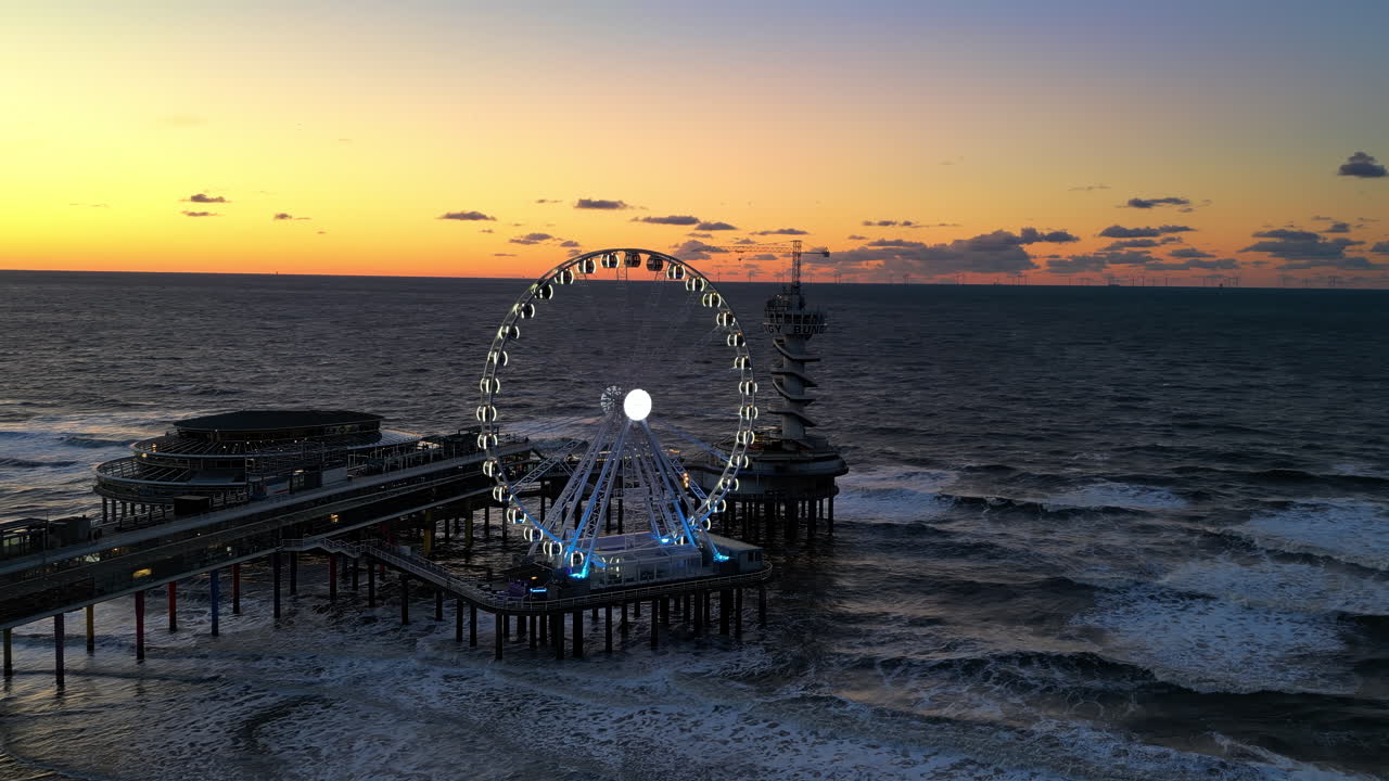 The Hague, Netherlands - November 21, 2024: Aerial drone view of the Scheveningen Pier and Ferris Wheel at the Dutch North Sea Coast