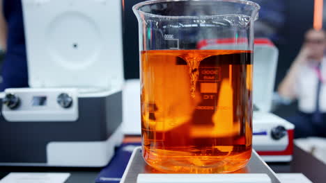 orange liquid stirred in a beaker in a laboratory setting