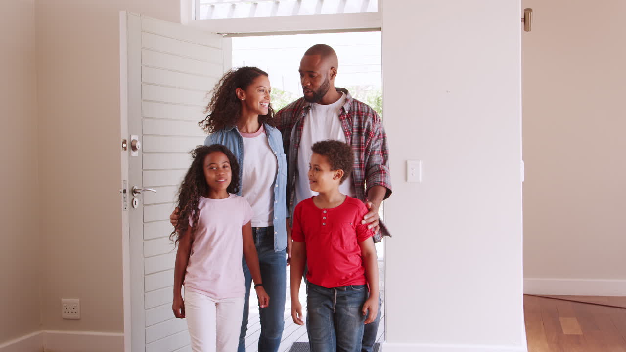 Family Opening Door And Walking In Empty Lounge Of New Home