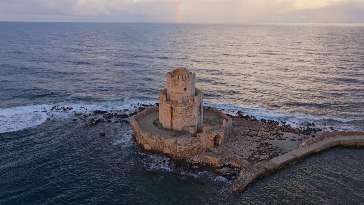 Flyfoto av levende regnbue over det gamle Methoni-slottet ved soloppgang