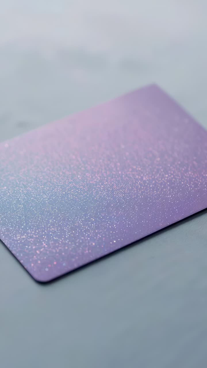 Vertical video: Panning camera revealing glittery purple mat on pale marble table, showing sparkles