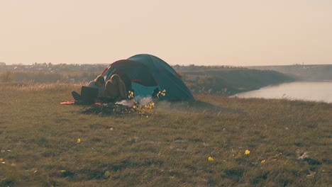 women-with-tablet-and-laptop-at-tent-and-bonfire-slow-motion