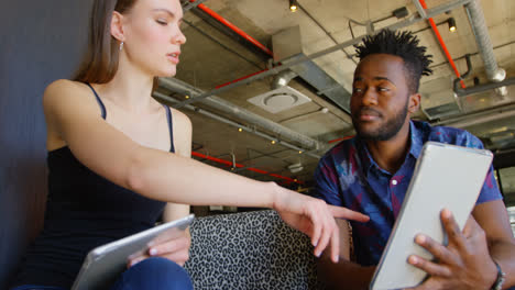 Front-view-of-young-cool-mixed-race-business-team-planning-and-sitting-on-couch-of-modern-office-4k