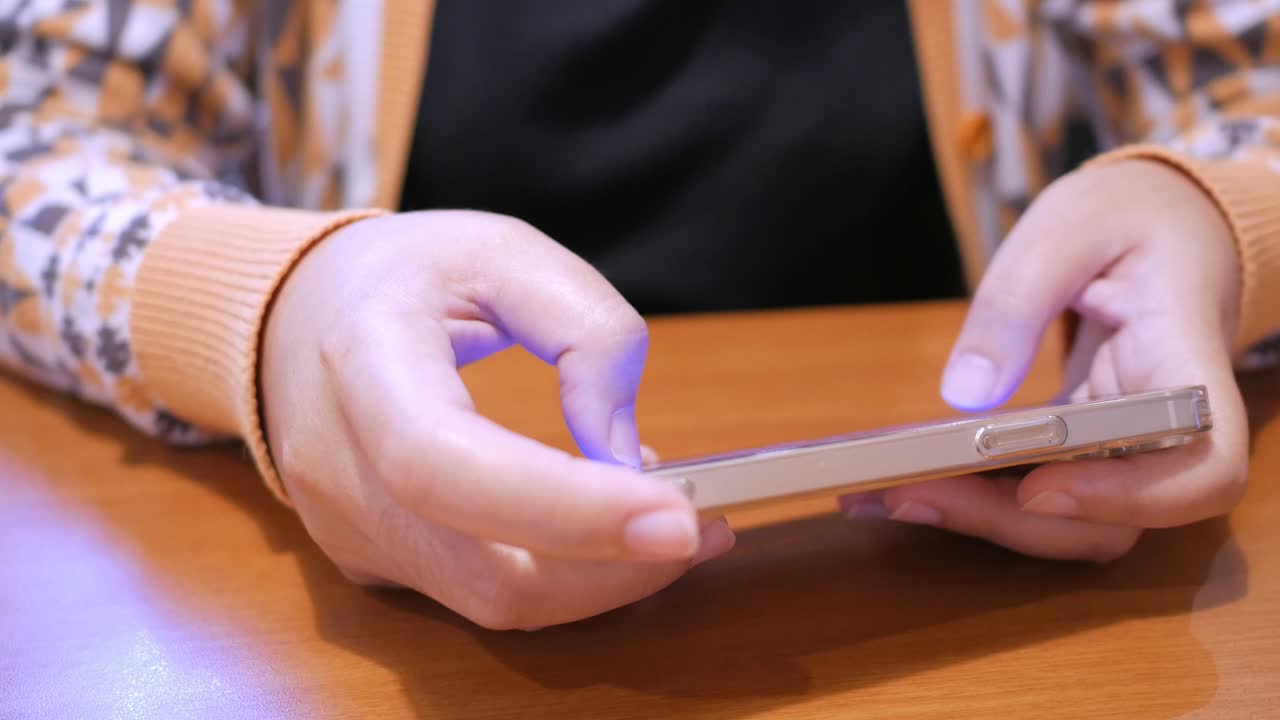 primer plano de un individuo jugando algunos juegos en línea usando un teléfono móvil inteligente