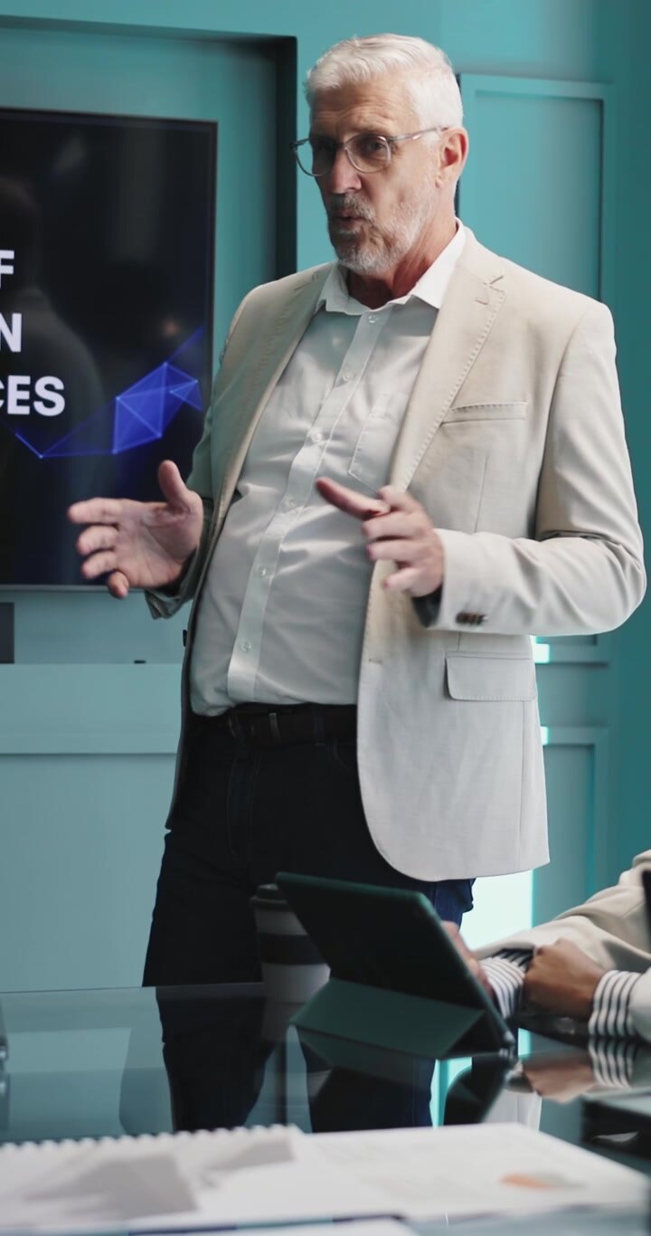 Uomo d'affari maturo che tiene una presentazione durante una riunione in un ufficio moderno