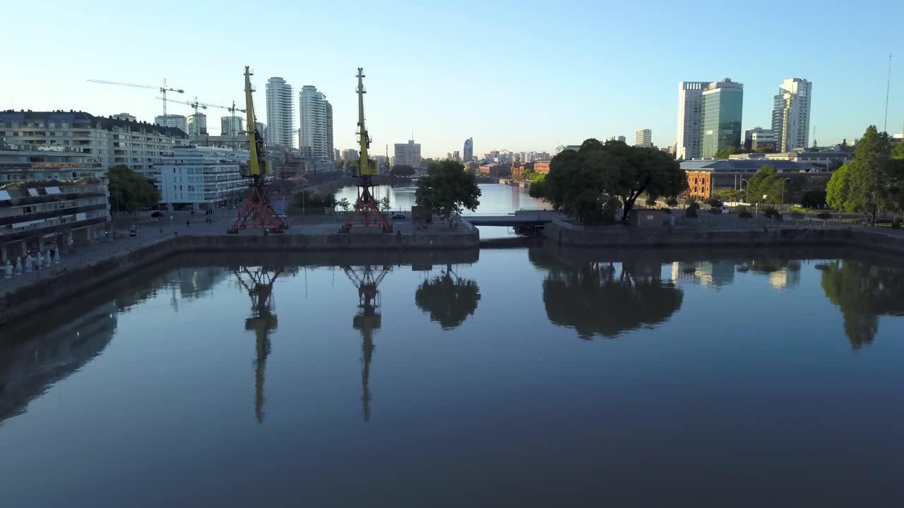 Luftaufnahme des Wassers der Puerto Madero Docks, das am Morgen die Stadtlandschaft widerspiegelt.