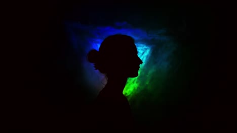 image of young girl on light background of different colors moving in the dark. smoke fills the triangle with the girl's head.