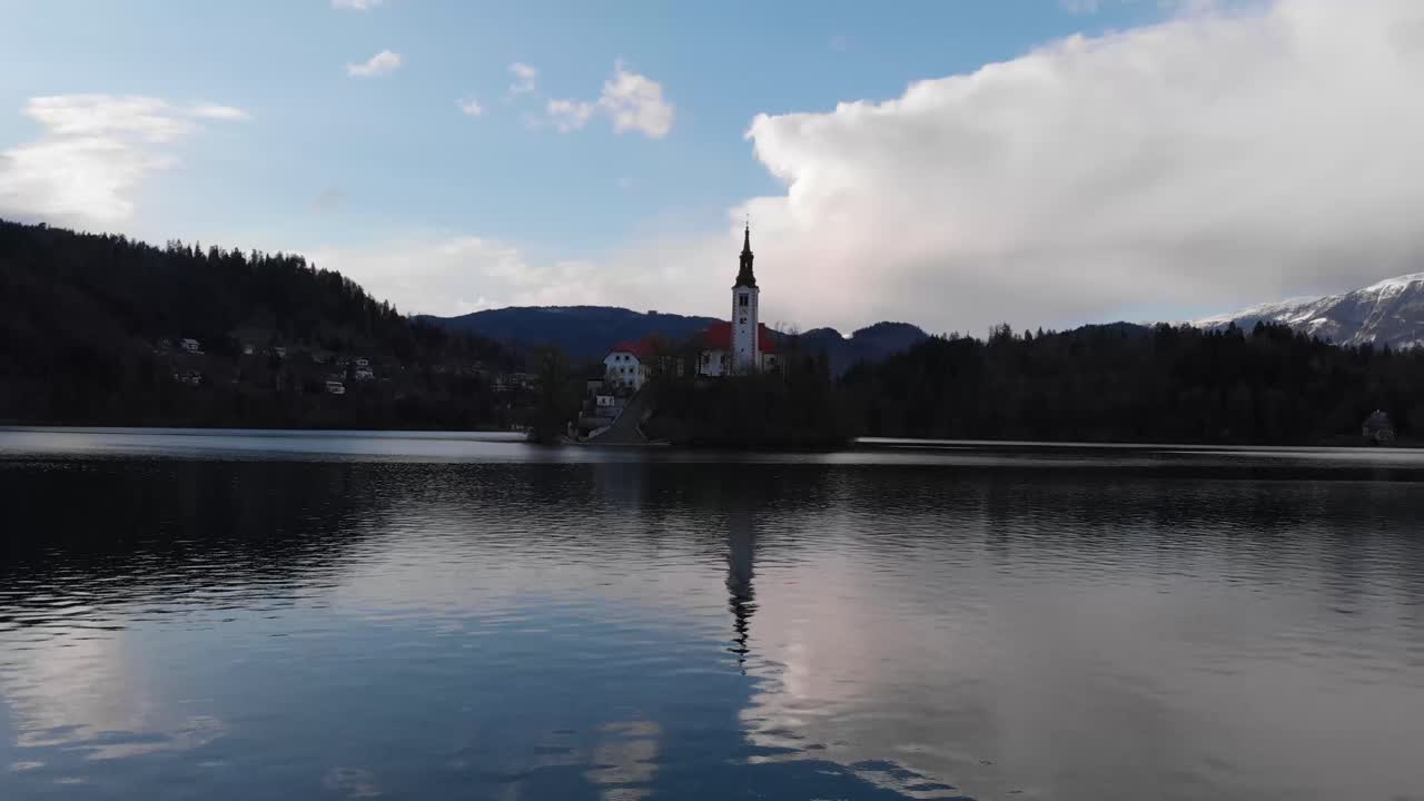 Church of the Assumption of Maria. Aerial view of Island in Bled Lake. Charming autumn panorama landscape of island with church rounded colorful trees in the middle of Bled lake.
